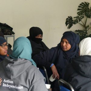 A group of Somali women talk together. They are seated in a group